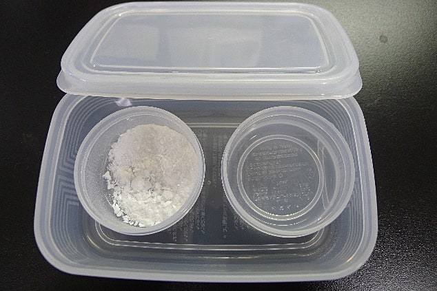 粉末試料を水和している様子粉末試料を水和している様子。左がタンパク質粉末で、右の容器に超純水が入れられている。水和の際はタッパの蓋を閉め、密閉して行う。