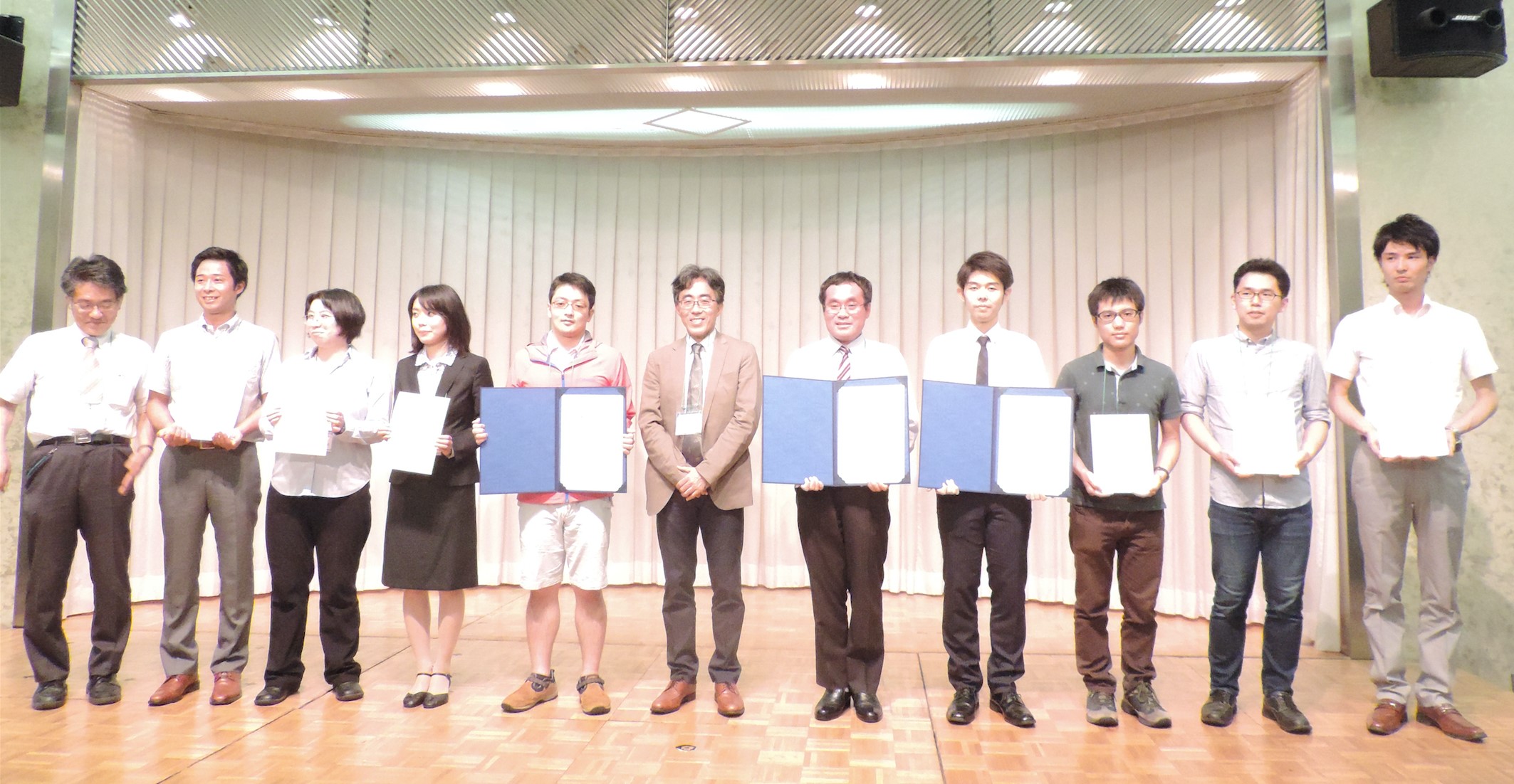若手奨励賞受者（左端：辻年会長、中央：遠藤会長、青色カバー付き賞状を持つ優秀賞受賞者）